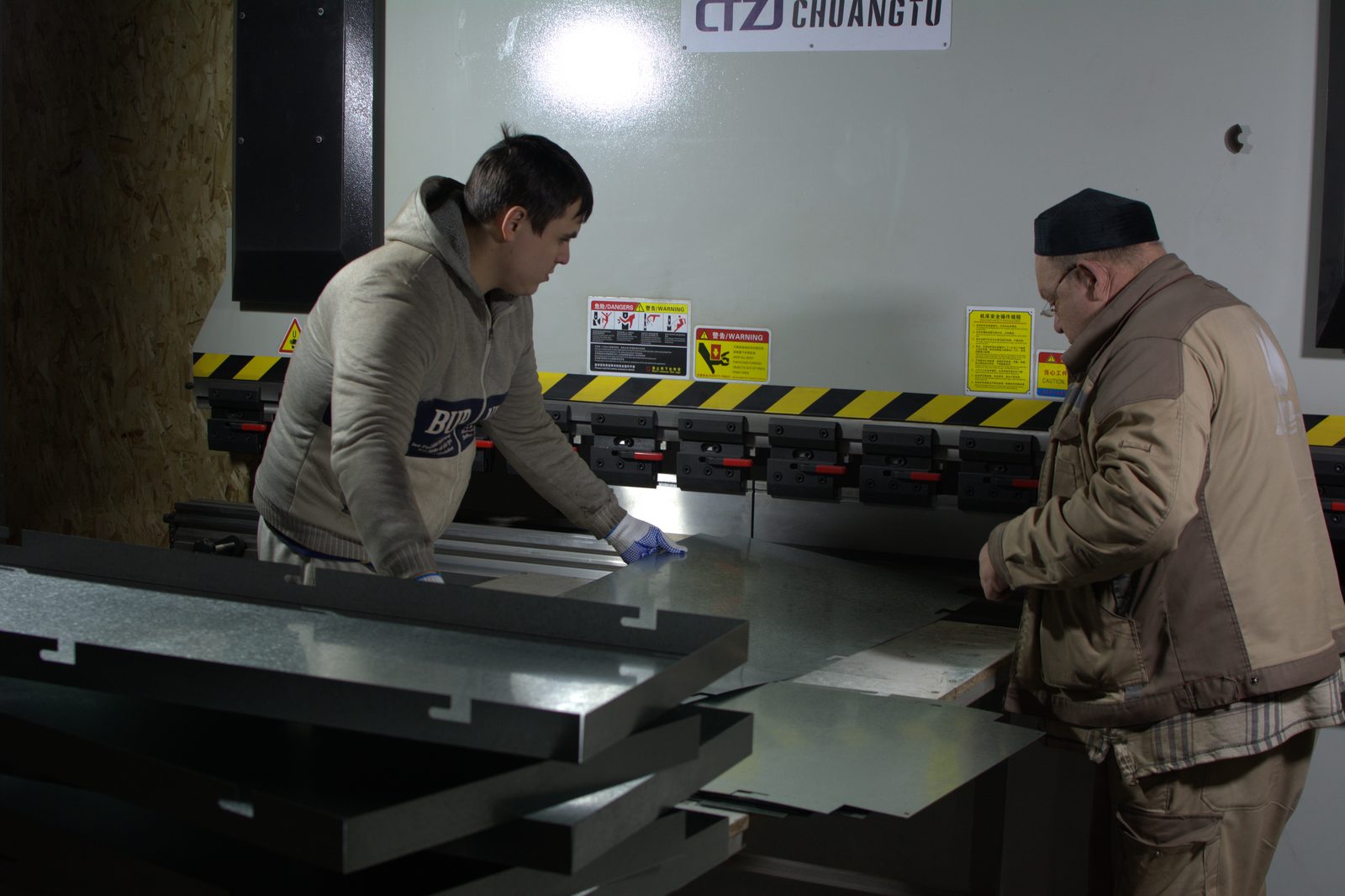 Операторы СтальПро формуют лист оцинкованной стали на листогибочном прессе с ЧПУ